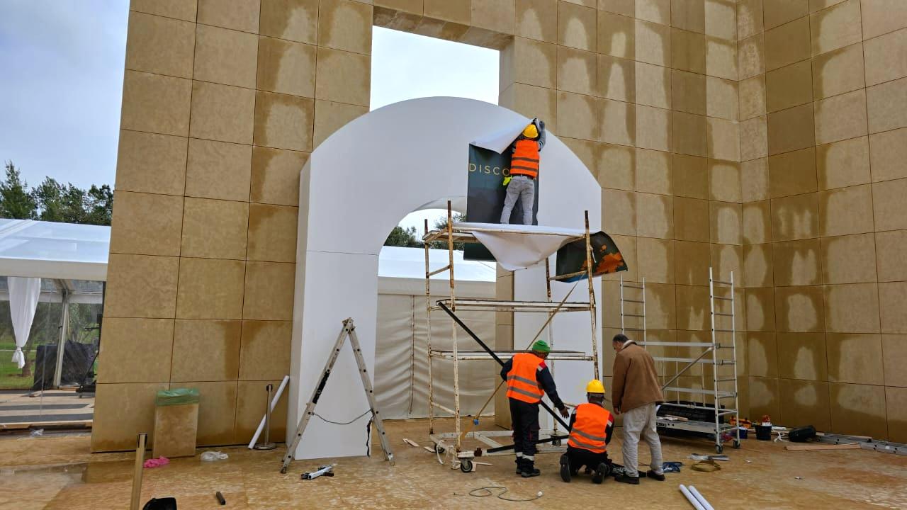 Pose d’une arche d’entrée en extérieur, équipe en tenue de sécurité.